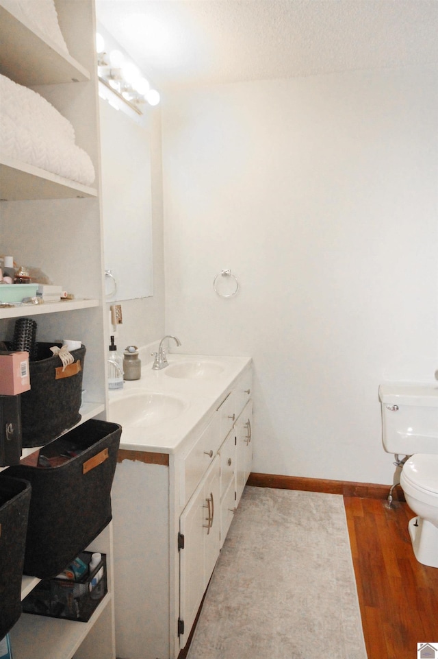 bathroom featuring hardwood / wood-style flooring, a textured ceiling, vanity, and toilet