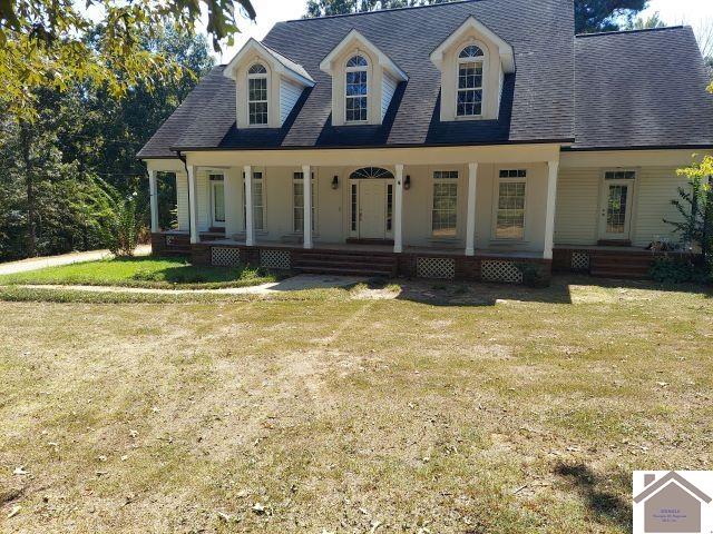 cape cod house featuring a front lawn and a porch