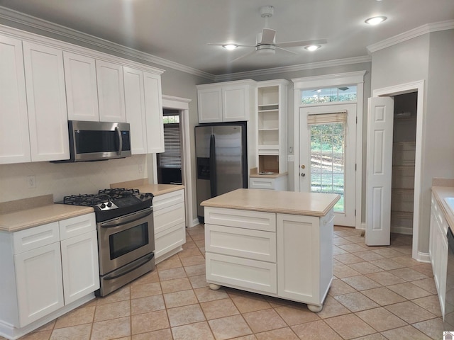 kitchen featuring white cabinets, a kitchen island, stainless steel appliances, crown molding, and ceiling fan