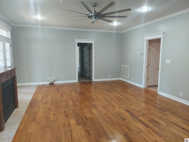 unfurnished living room with ceiling fan, a fireplace, crown molding, and light hardwood / wood-style floors