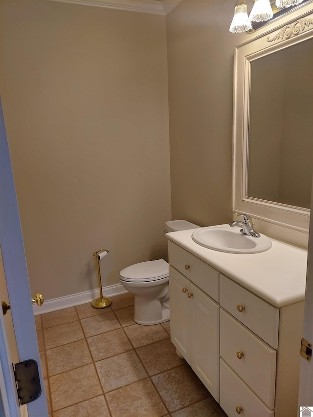 bathroom with vanity, crown molding, and toilet