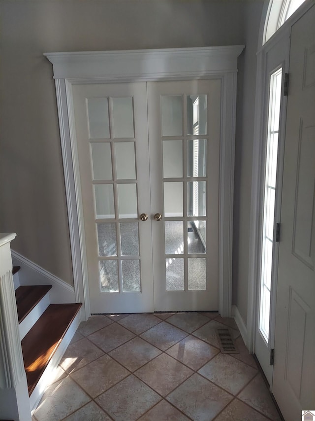 interior space with french doors, visible vents, and stairway