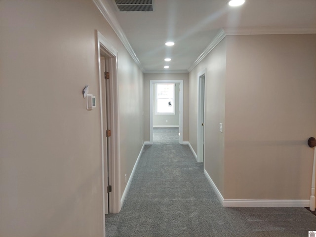 corridor with crown molding and dark colored carpet