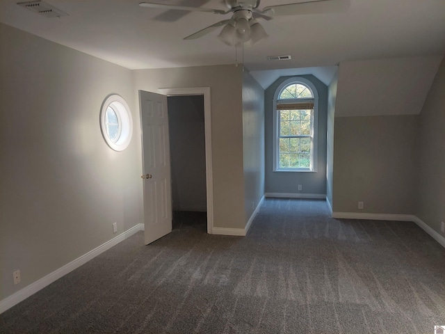 interior space with ceiling fan and dark carpet