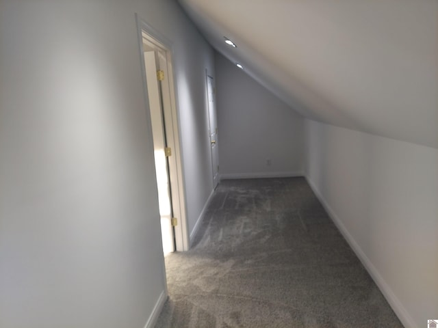 bonus room with dark colored carpet and vaulted ceiling