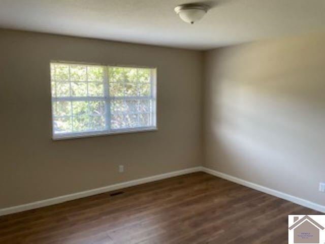 spare room with dark hardwood / wood-style floors