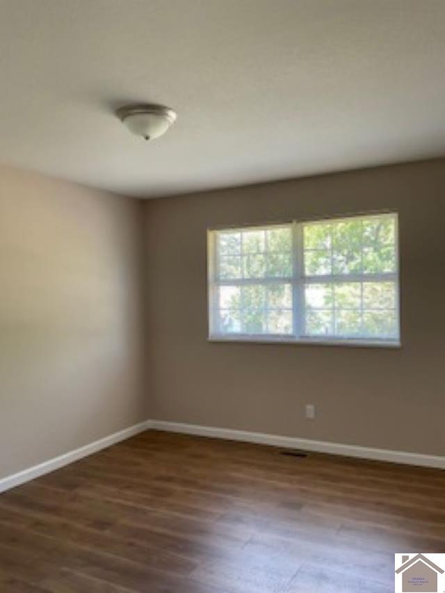 spare room with hardwood / wood-style flooring and a healthy amount of sunlight