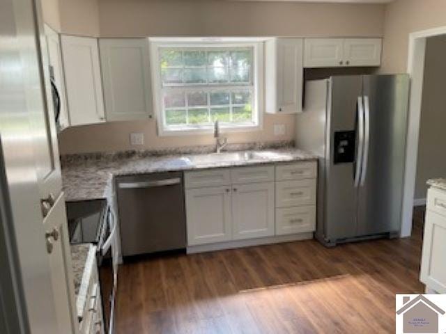 kitchen with white cabinets, appliances with stainless steel finishes, and dark hardwood / wood-style flooring