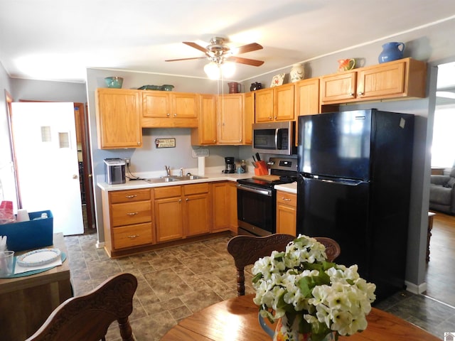 kitchen featuring ceiling fan, sink, dark tile patterned floors, and stainless steel appliances