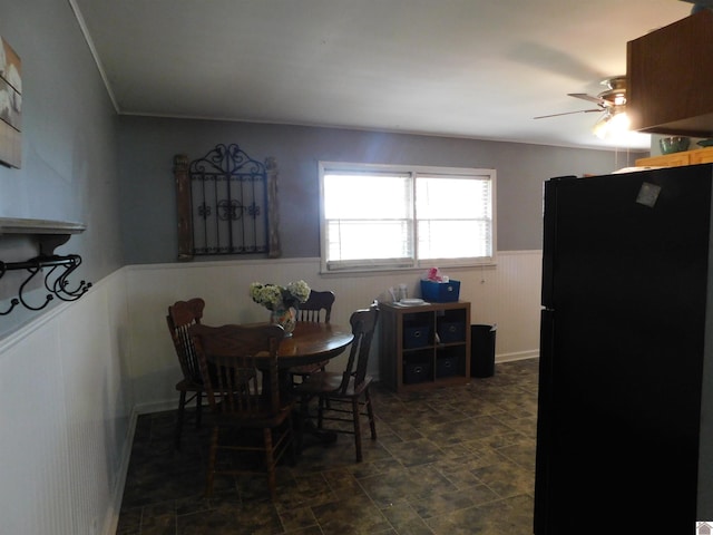 dining space featuring ceiling fan and dark tile patterned flooring