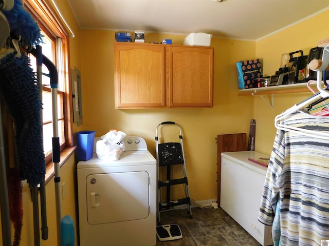 clothes washing area with cabinets, dark tile patterned floors, and electric panel