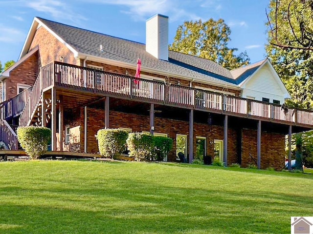 rear view of property featuring a wooden deck and a lawn