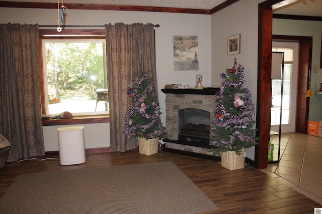 unfurnished living room with crown molding, hardwood / wood-style floors, and a stone fireplace