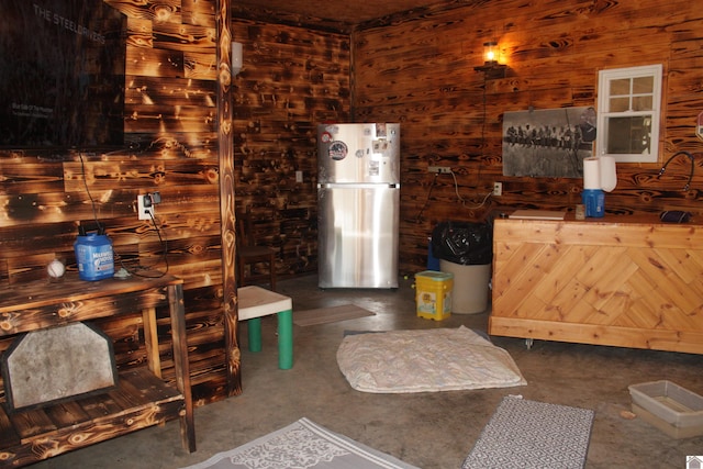 interior space featuring stainless steel fridge and wooden walls