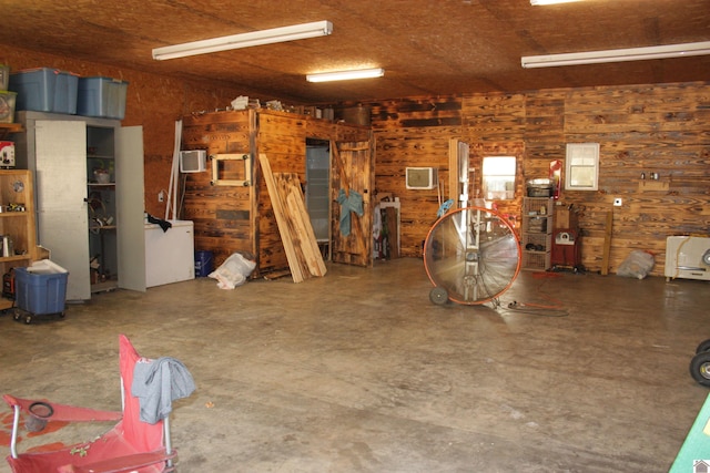 interior space with concrete flooring and wood walls