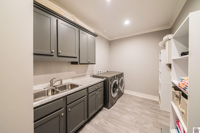 laundry area with separate washer and dryer, ornamental molding, cabinets, and sink