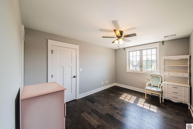 unfurnished room with ceiling fan, dark wood finished floors, visible vents, and baseboards
