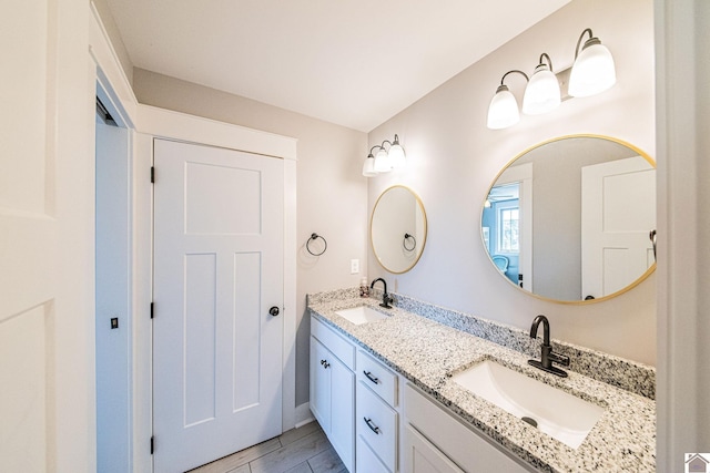 full bathroom with a sink and double vanity