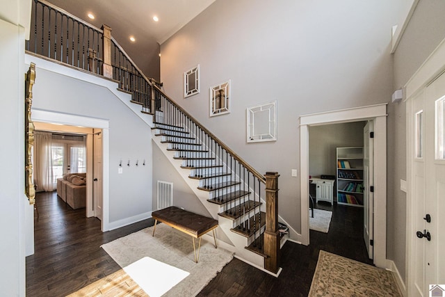 stairway with a high ceiling and hardwood / wood-style floors