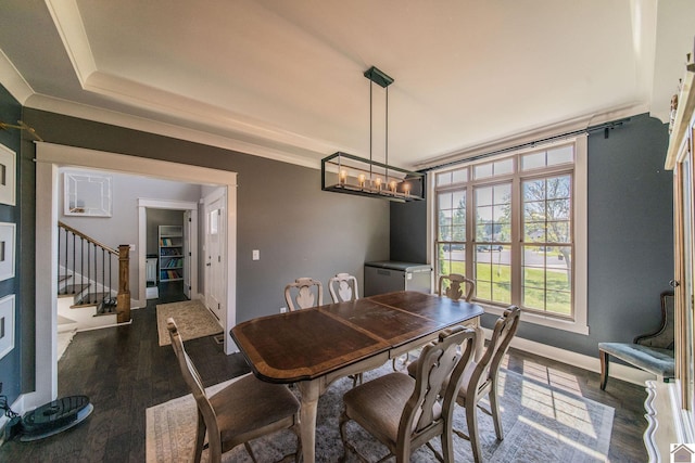 dining area featuring a raised ceiling, a chandelier, and hardwood / wood-style floors