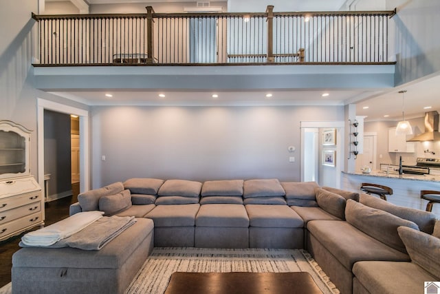 living room featuring a towering ceiling and light hardwood / wood-style floors