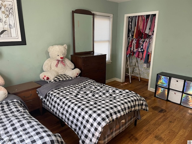 bedroom featuring a closet, wood finished floors, and baseboards