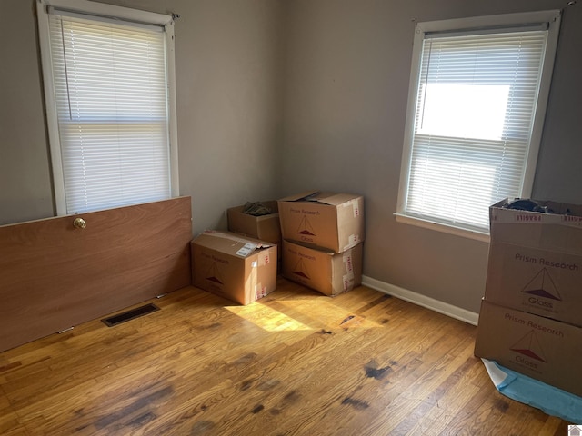 bedroom featuring baseboards, visible vents, and light wood finished floors