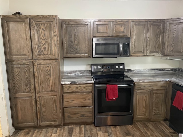 kitchen featuring black dishwasher, stainless steel microwave, dark wood-type flooring, and electric stove