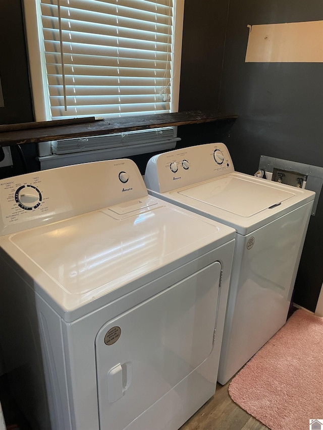 clothes washing area featuring laundry area, light wood finished floors, and washing machine and clothes dryer