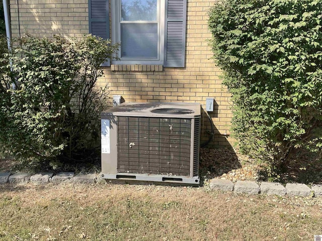 exterior details with cooling unit and brick siding