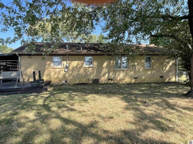 rear view of property featuring a wooden deck and a yard