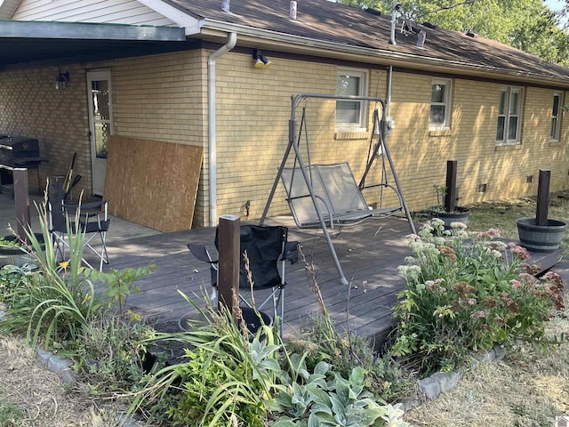 rear view of property with brick siding and a deck