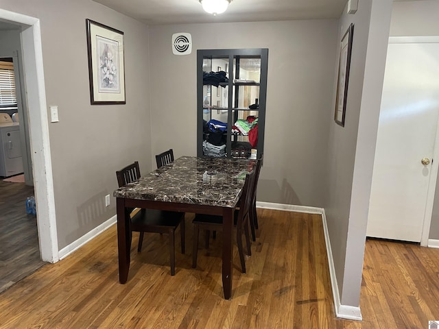 dining space with baseboards, visible vents, washer / clothes dryer, and wood finished floors