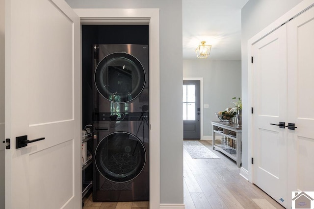 washroom featuring light hardwood / wood-style flooring and stacked washer and dryer