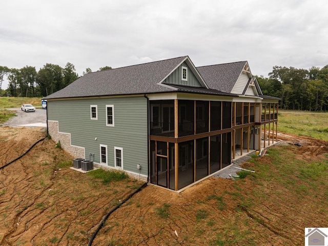 rear view of house with a sunroom and central AC