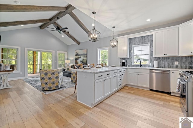 kitchen featuring light hardwood / wood-style flooring, appliances with stainless steel finishes, white cabinetry, kitchen peninsula, and high vaulted ceiling