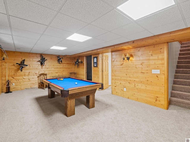 recreation room with a drop ceiling, billiards, wooden walls, and carpet