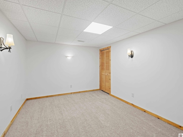 carpeted spare room with a paneled ceiling