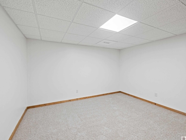 empty room with carpet flooring and a drop ceiling