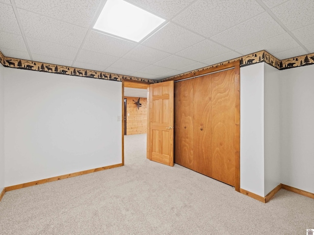 basement with carpet flooring and a drop ceiling