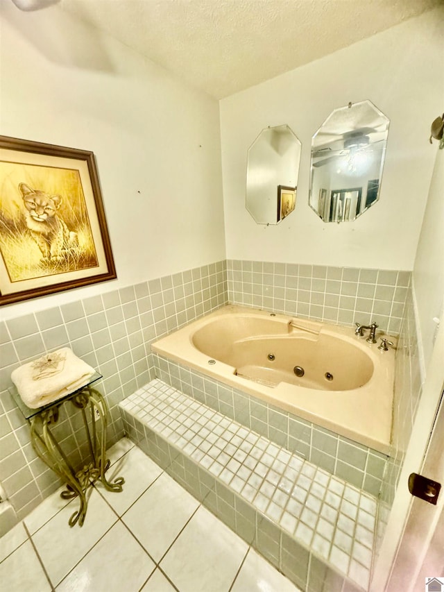 bathroom featuring a relaxing tiled tub, a textured ceiling, and tile patterned flooring