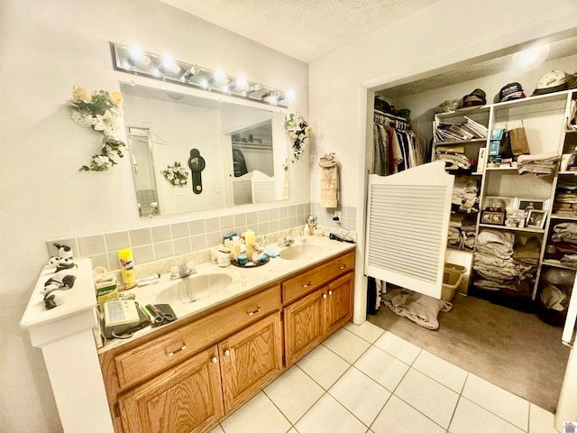 bathroom featuring vanity, decorative backsplash, a textured ceiling, and tile patterned floors