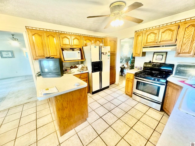 kitchen with white appliances, a kitchen island, a textured ceiling, ceiling fan, and light tile patterned floors