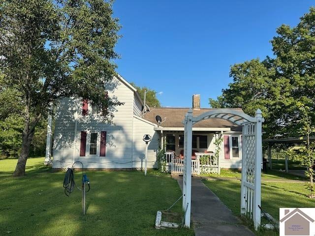 back of house with covered porch, a pergola, and a yard