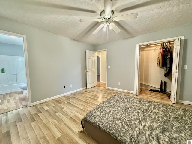 unfurnished bedroom featuring a textured ceiling, light hardwood / wood-style flooring, ceiling fan, and a closet