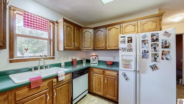 kitchen featuring white appliances, a wealth of natural light, sink, and a textured ceiling