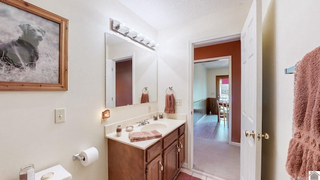 bathroom featuring tile patterned flooring, vanity, toilet, and a textured ceiling