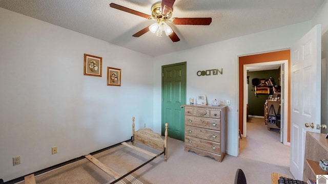 carpeted bedroom featuring a textured ceiling and ceiling fan