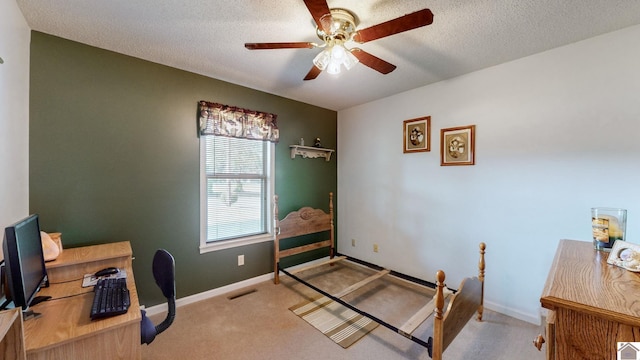 office space featuring ceiling fan, light colored carpet, and a textured ceiling