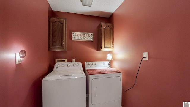 laundry area featuring a textured ceiling, cabinets, and separate washer and dryer